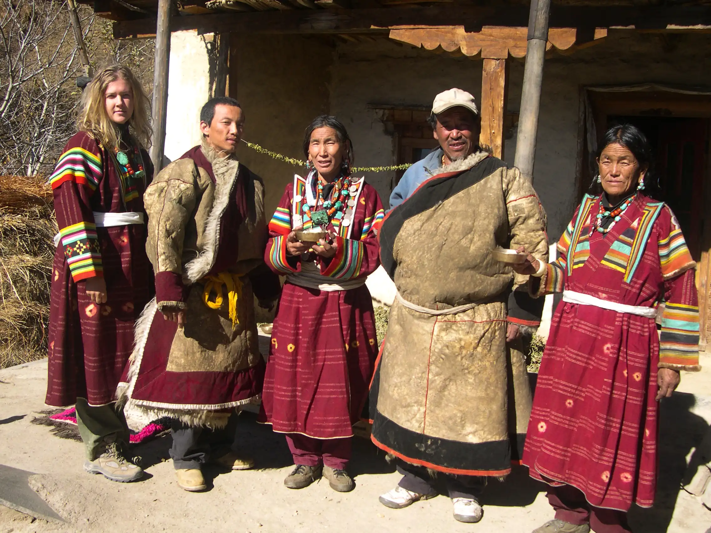 Trekking guests posing with local people in traditional Himalayan dress during a village visit